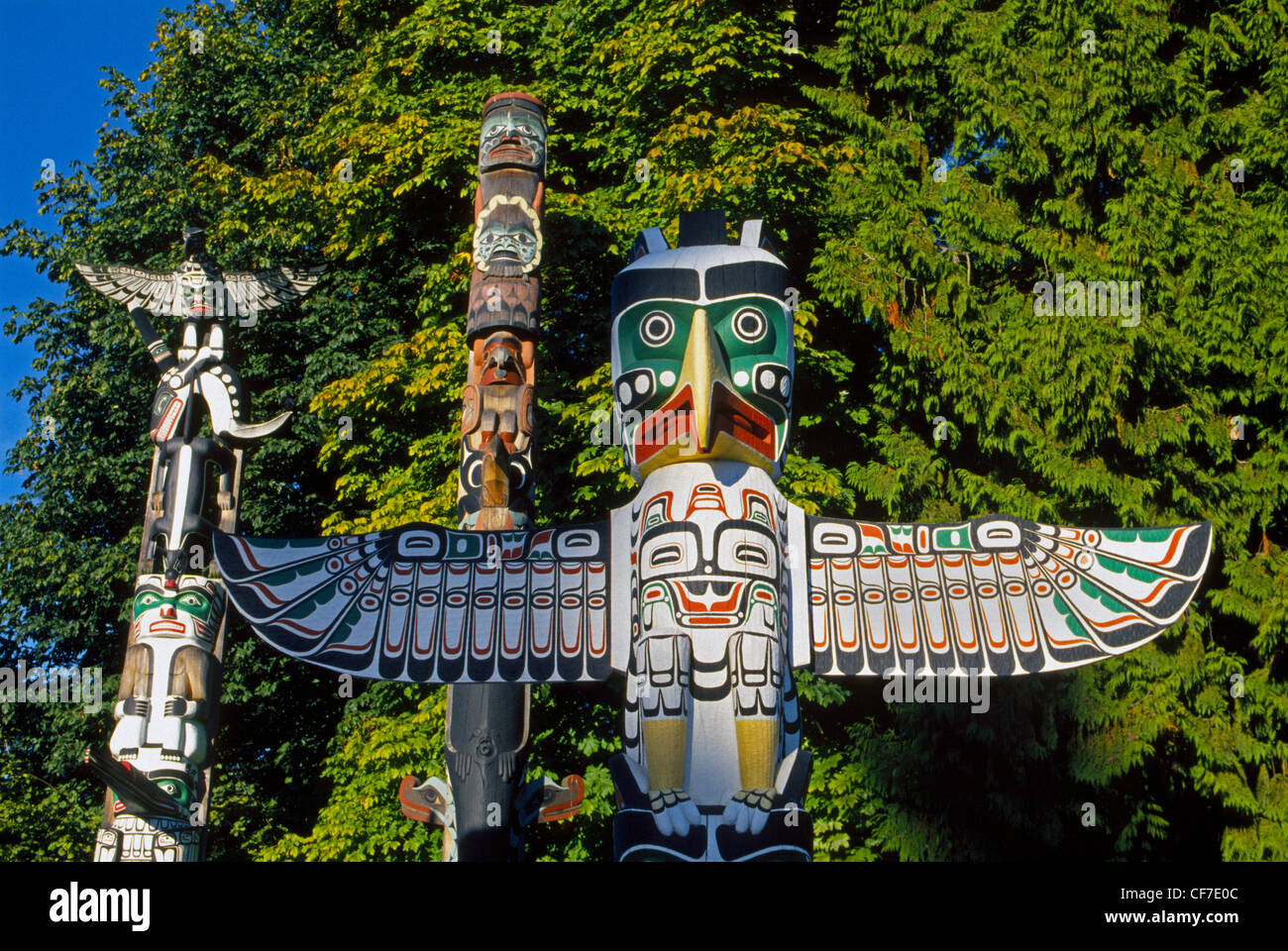 Figures and symbols of importance to First Nation peoples are carved into colorful wooden totem poles displayed in Vancouver, British Columbia, Canada. Stock Photo