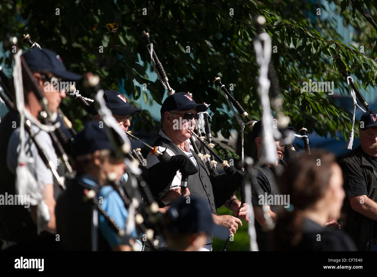 A group of pipers practice playing bagpipes in a Glasgow public park. Stock Photo