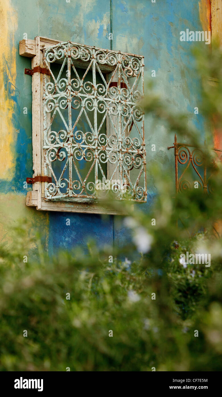 Colorful wall with wrought iron window covers in upscale neighborhood
