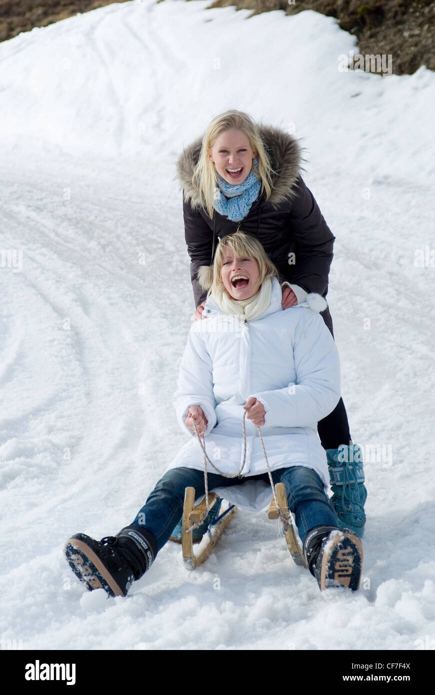 Two Females With Blonde Hair Wearing Brown And White Parkas And
