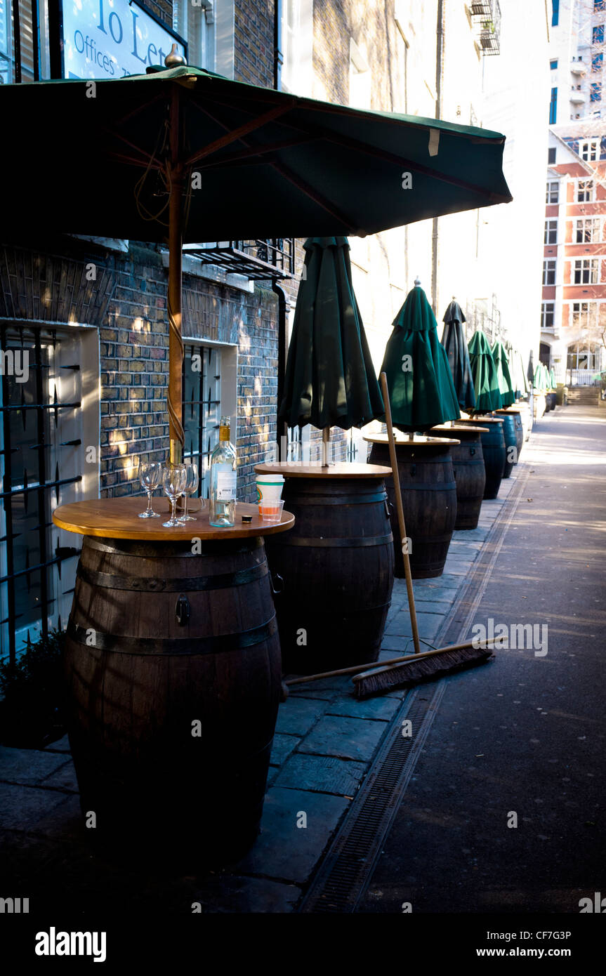 Empty glasses and bottles stand on a table outside a wine cellar at
