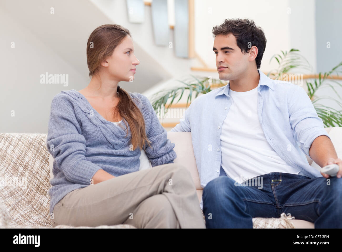 Couple having an argument while watching TV Stock Photo - Alamy