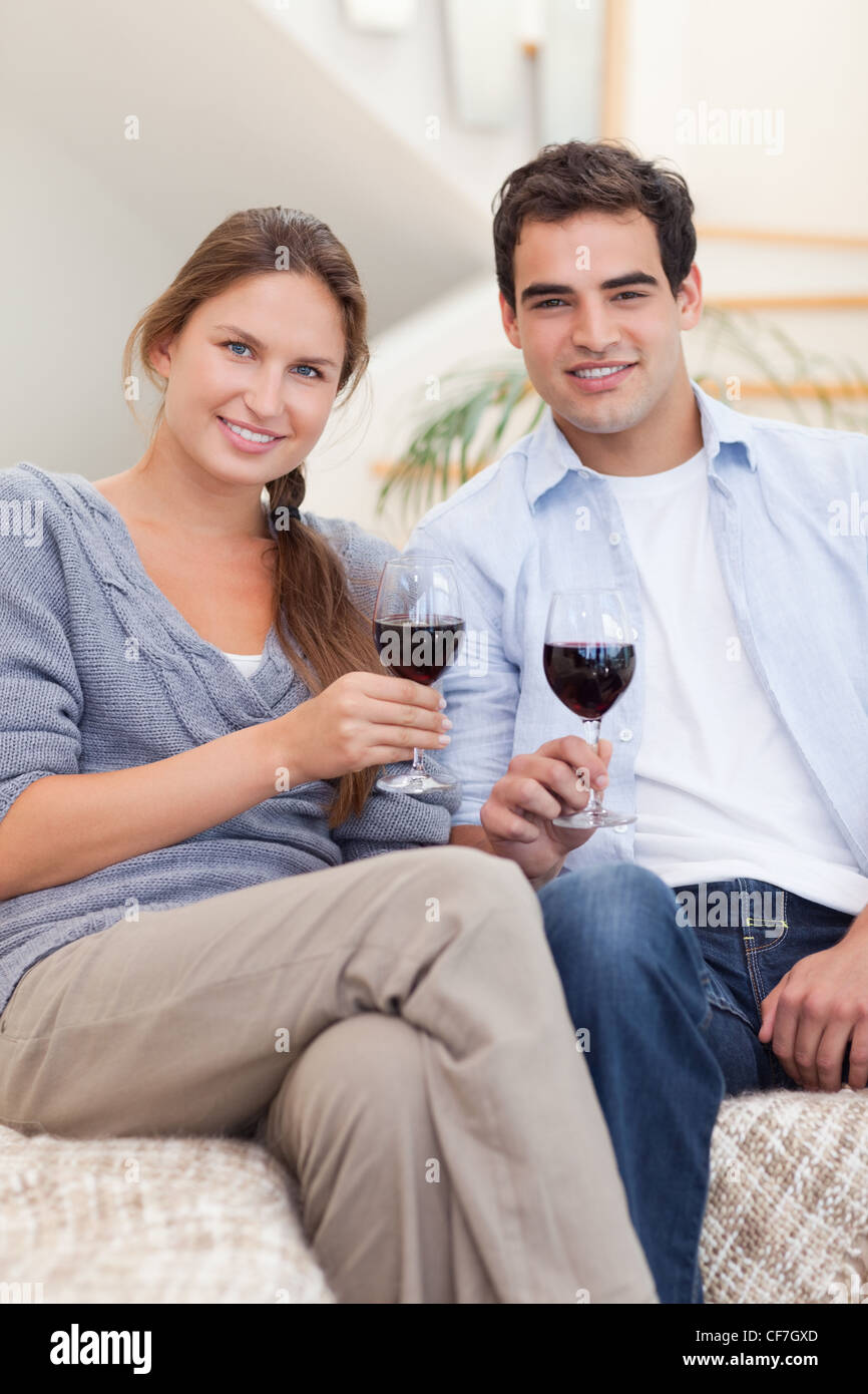 Portrait of a young couple having a glass of red wine Stock Photo - Alamy