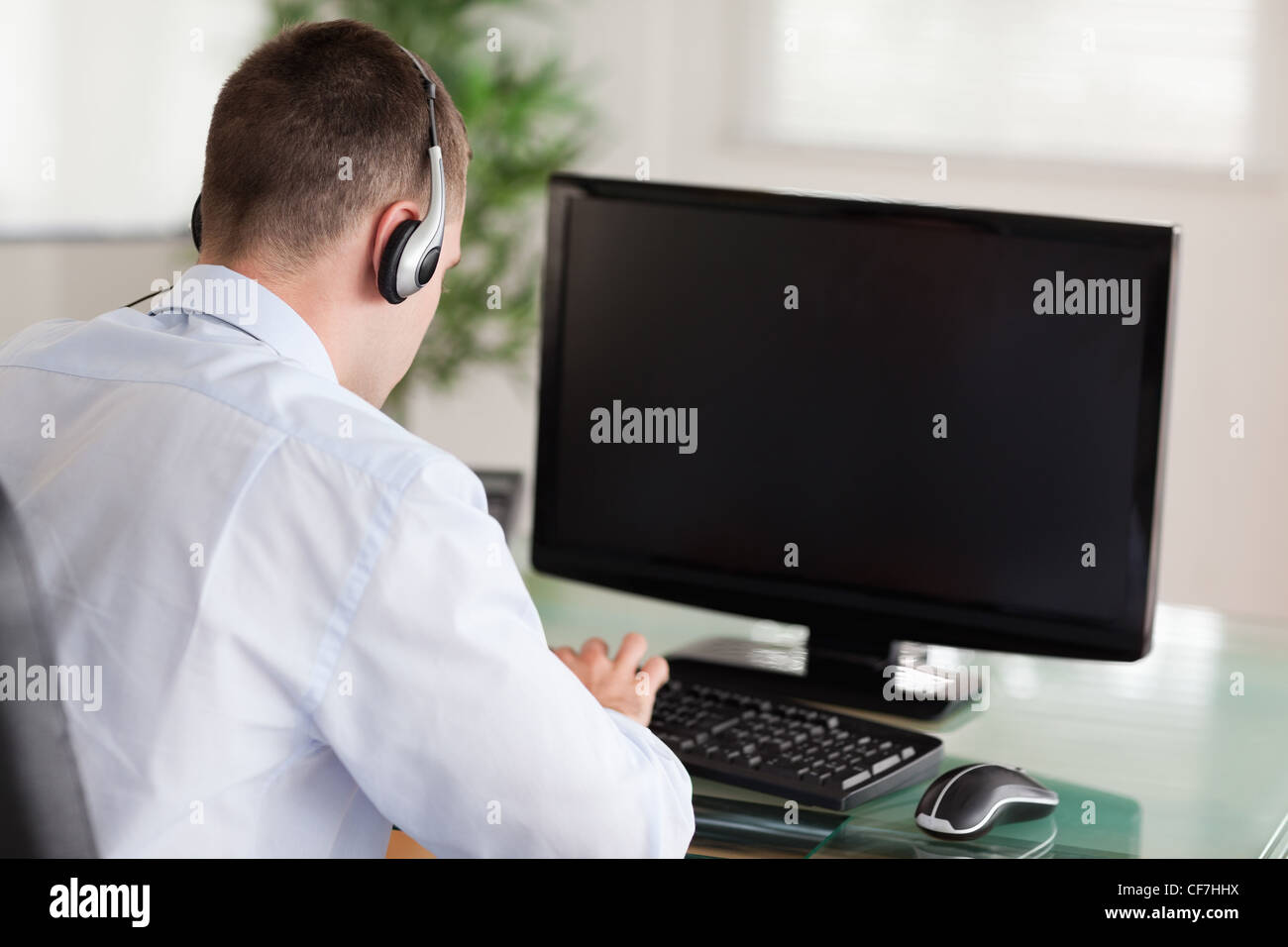 Call center agent looking for a solution in his computer Stock Photo