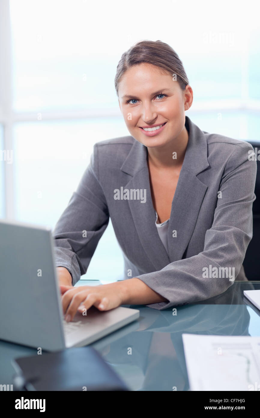 Portrait of a smiling businesswoman working with a laptop Stock Photo ...