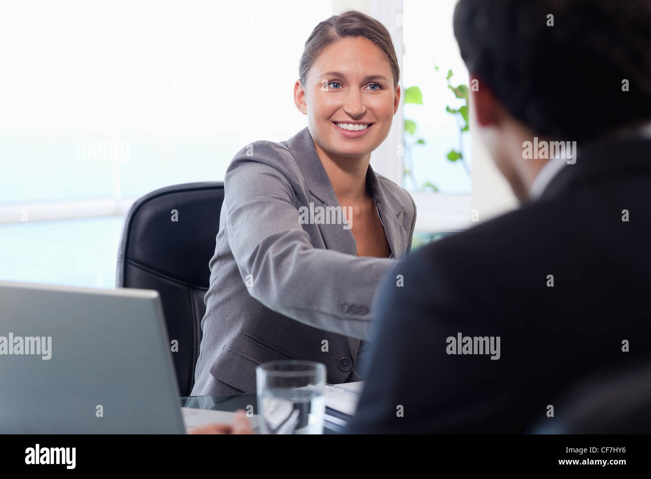 Smiling businesswoman welcomes customer Stock Photo