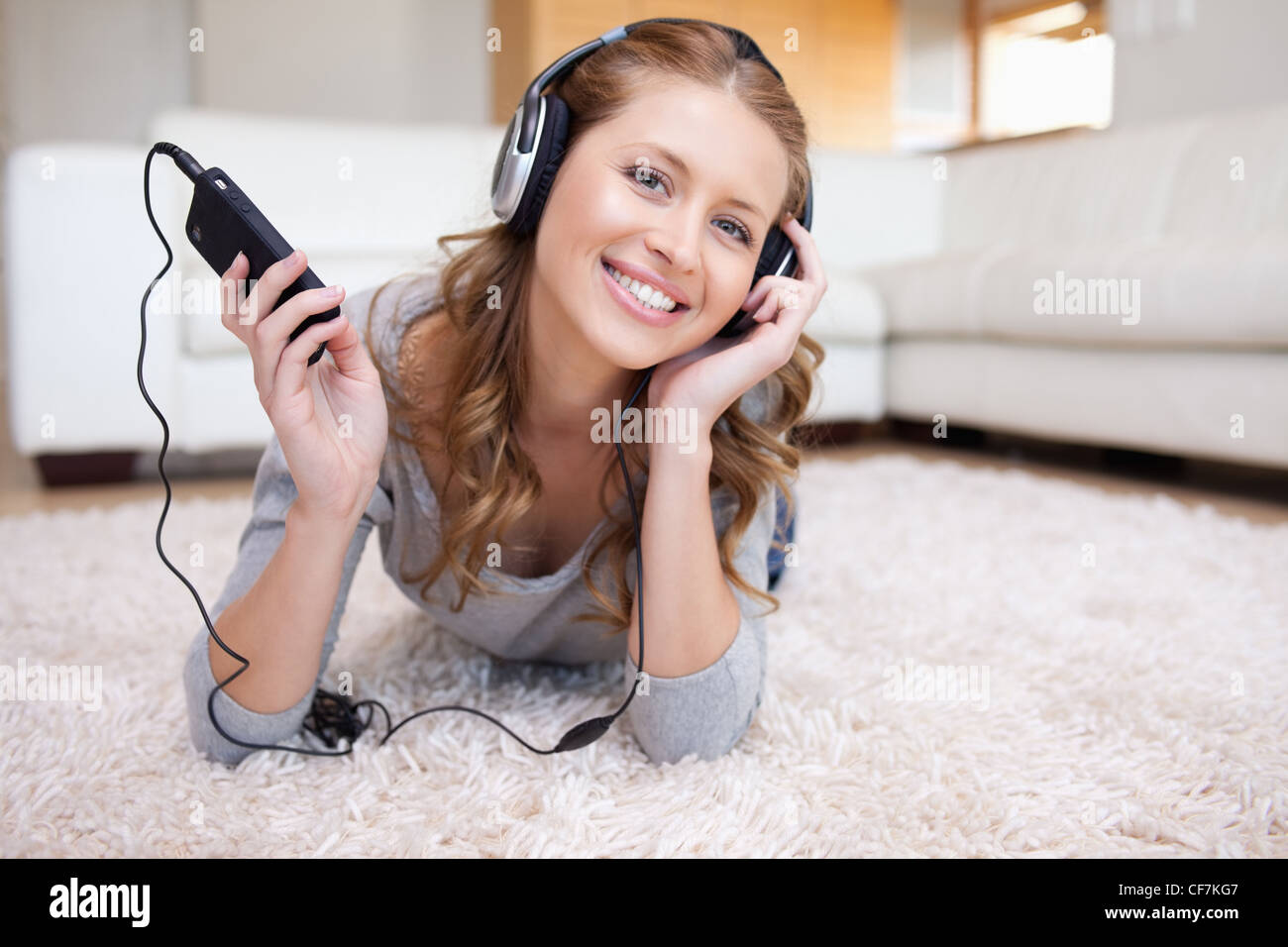 Woman lying on the floor enjoying music Stock Photo - Alamy