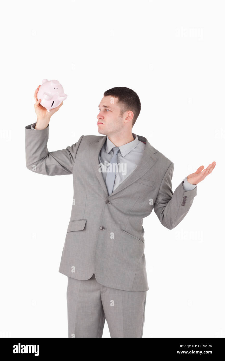 Portrait of a broke businessman looking at an empty piggy bank Stock ...