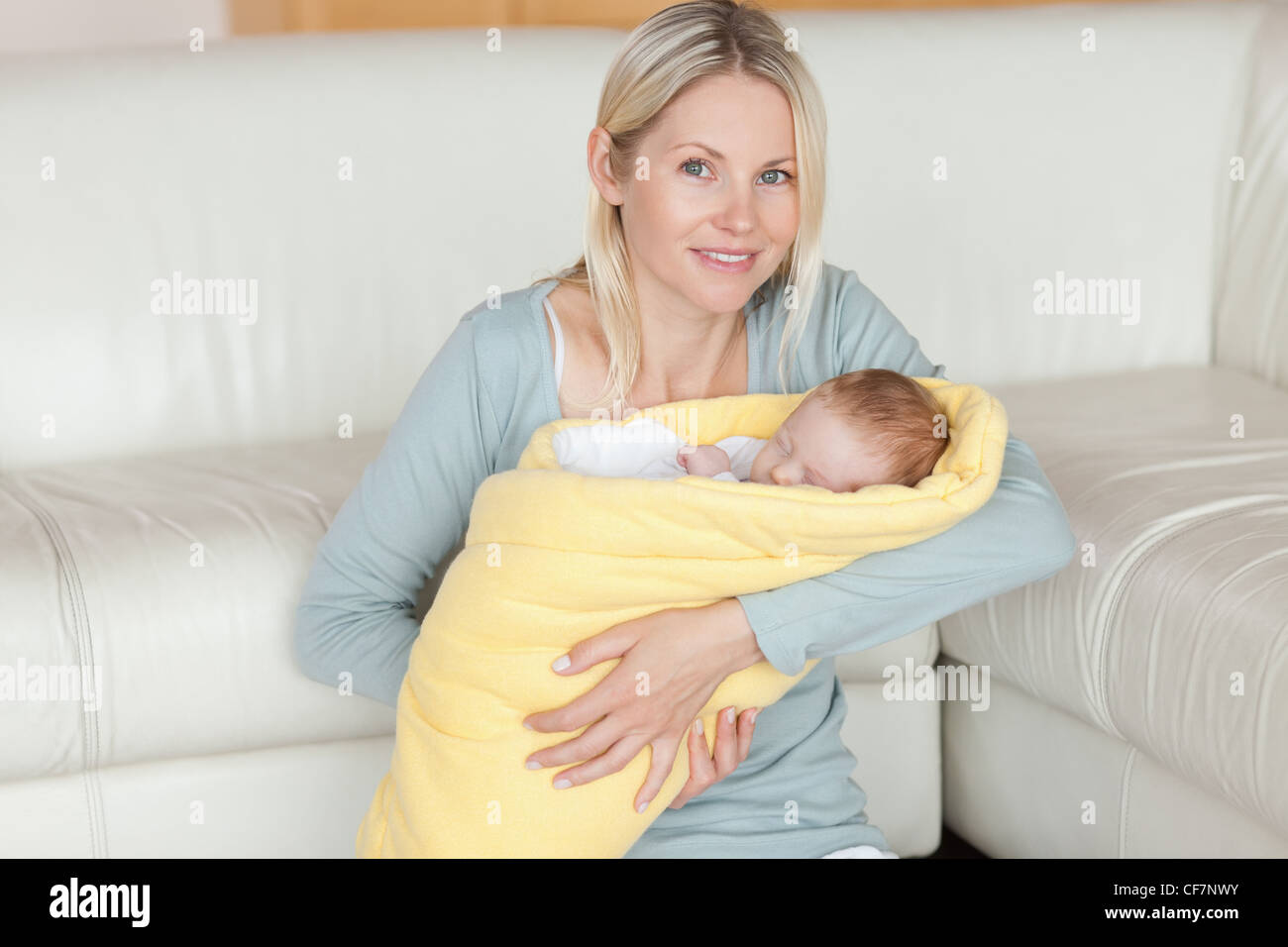 Mother sitting on the floor with her baby in her arms Stock Photo - Alamy