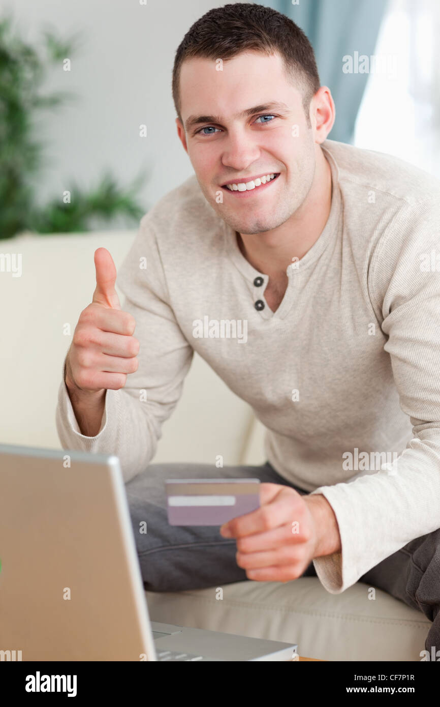 Portrait of a man purchasing online with the thumb up Stock Photo