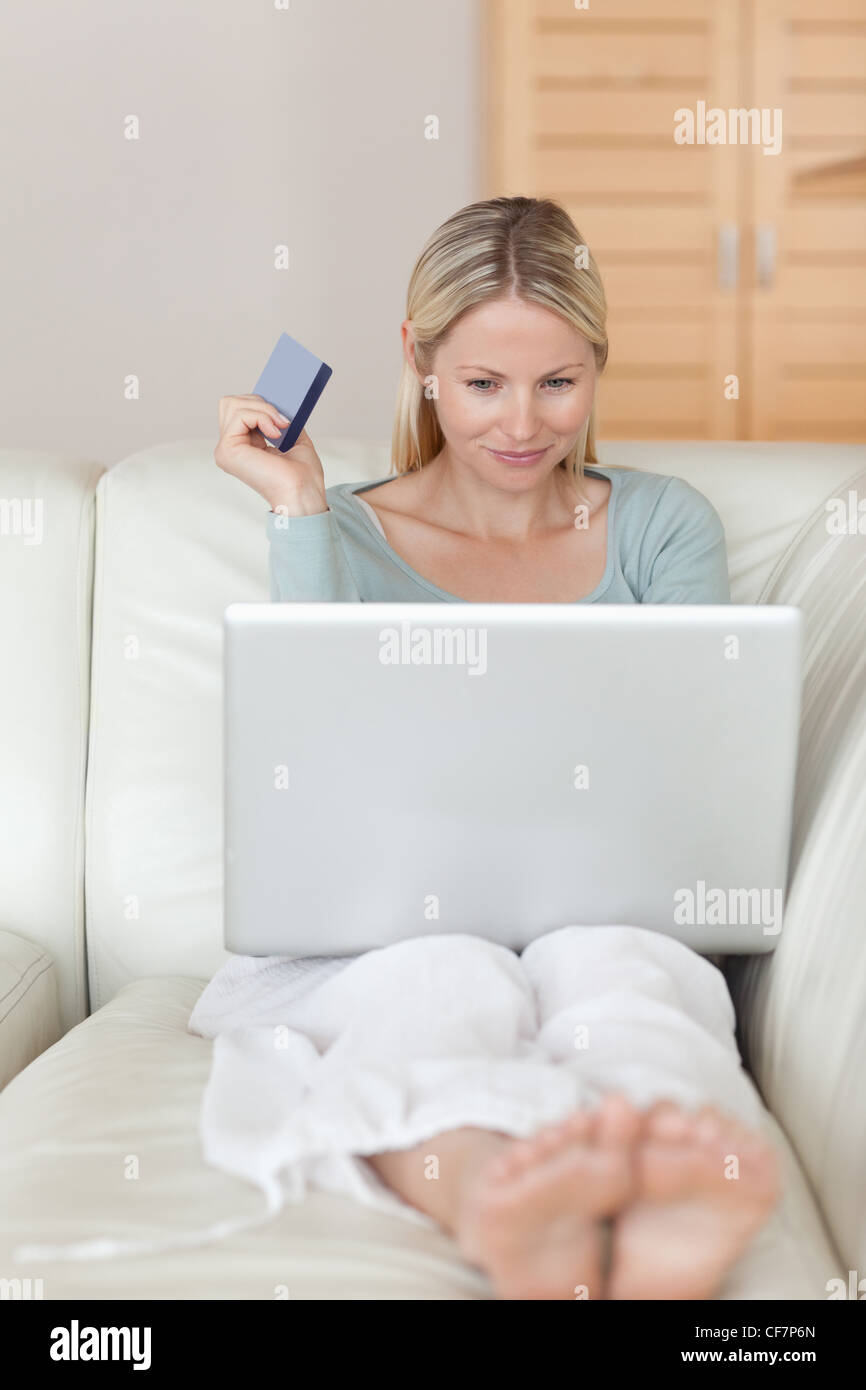 Woman on the sofa booking flight online Stock Photo