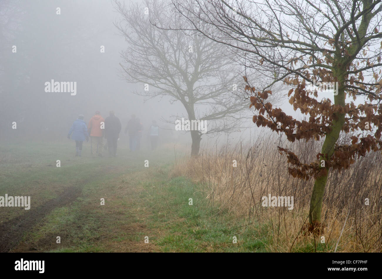 Group of walkers in the mist on a country track Stock Photo