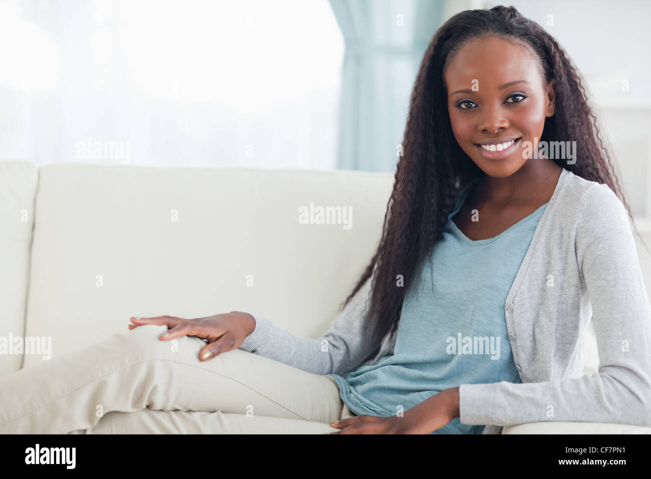 Smiling woman relaxing on sofa Stock Photo - Alamy