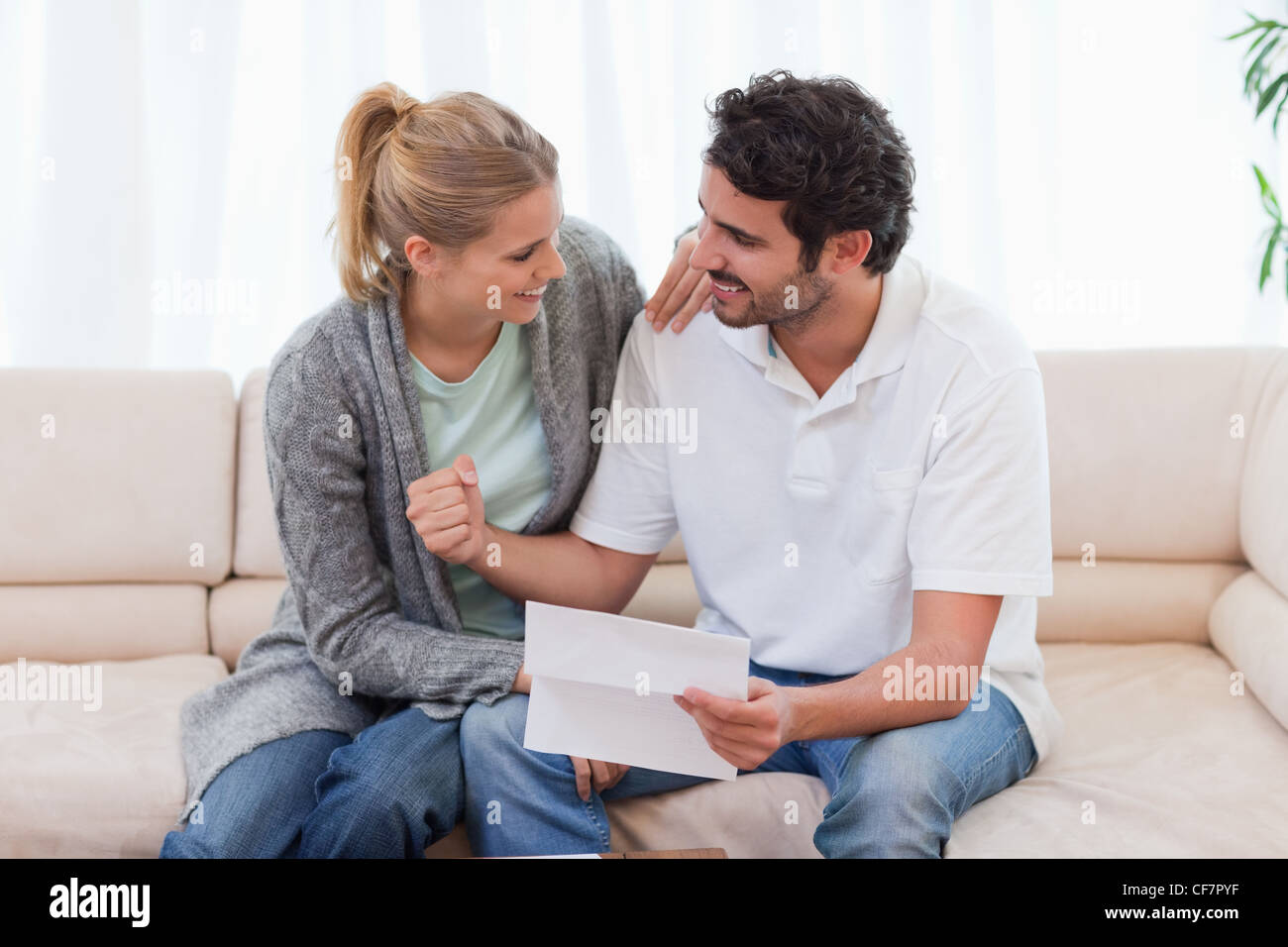 Happy couple reading a letter Stock Photo - Alamy