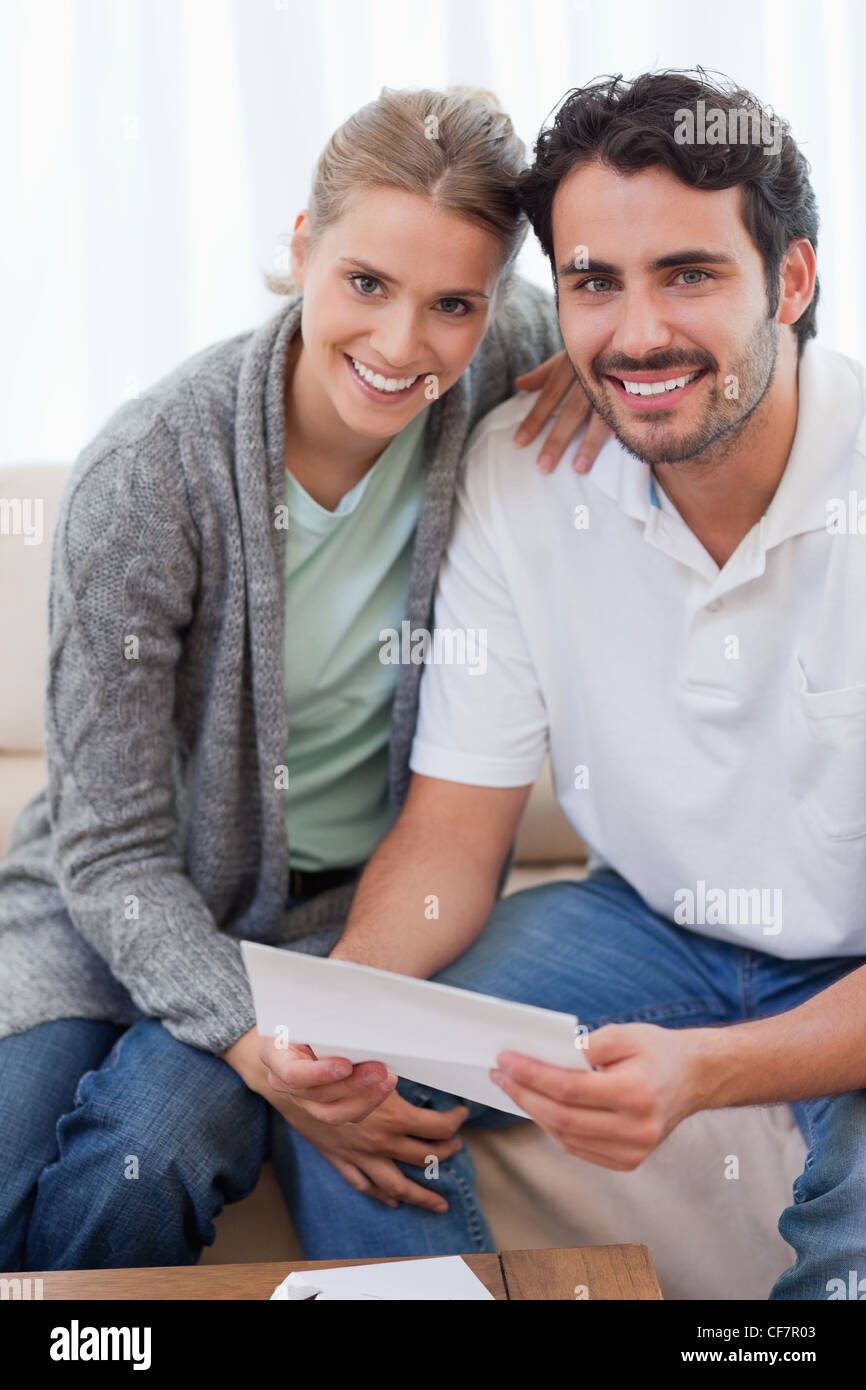 Portrait of a smiling couple reading a letter Stock Photo - Alamy