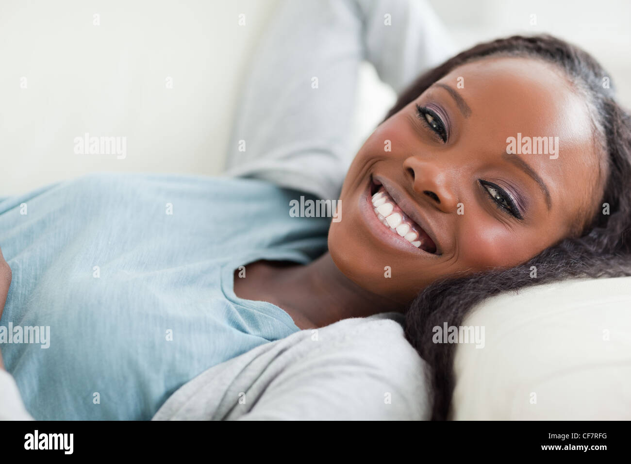 Close up of smiling woman taking a rest on the sofa Stock Photo - Alamy