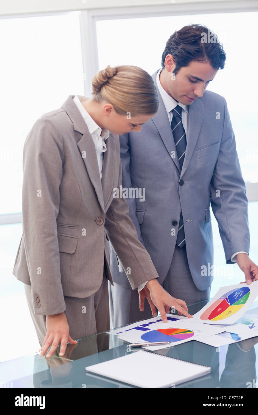 Portrait of young business people looking at statistics Stock Photo