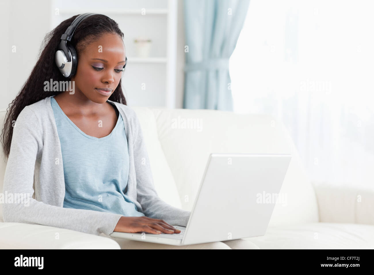 Woman with headphones on working on laptop Stock Photo - Alamy