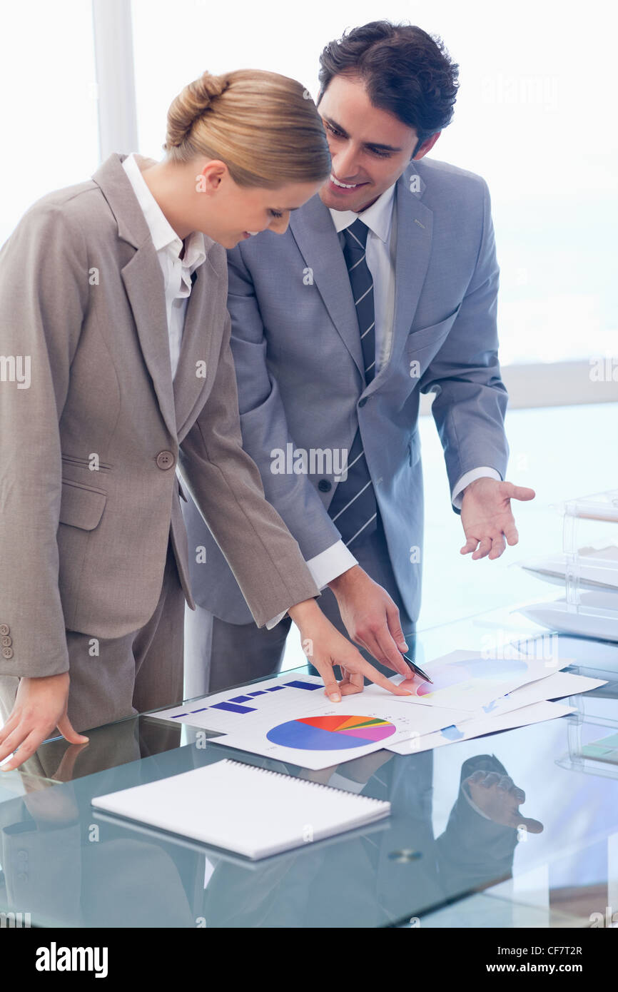 Portrait of smiling business people looking at statistics Stock Photo