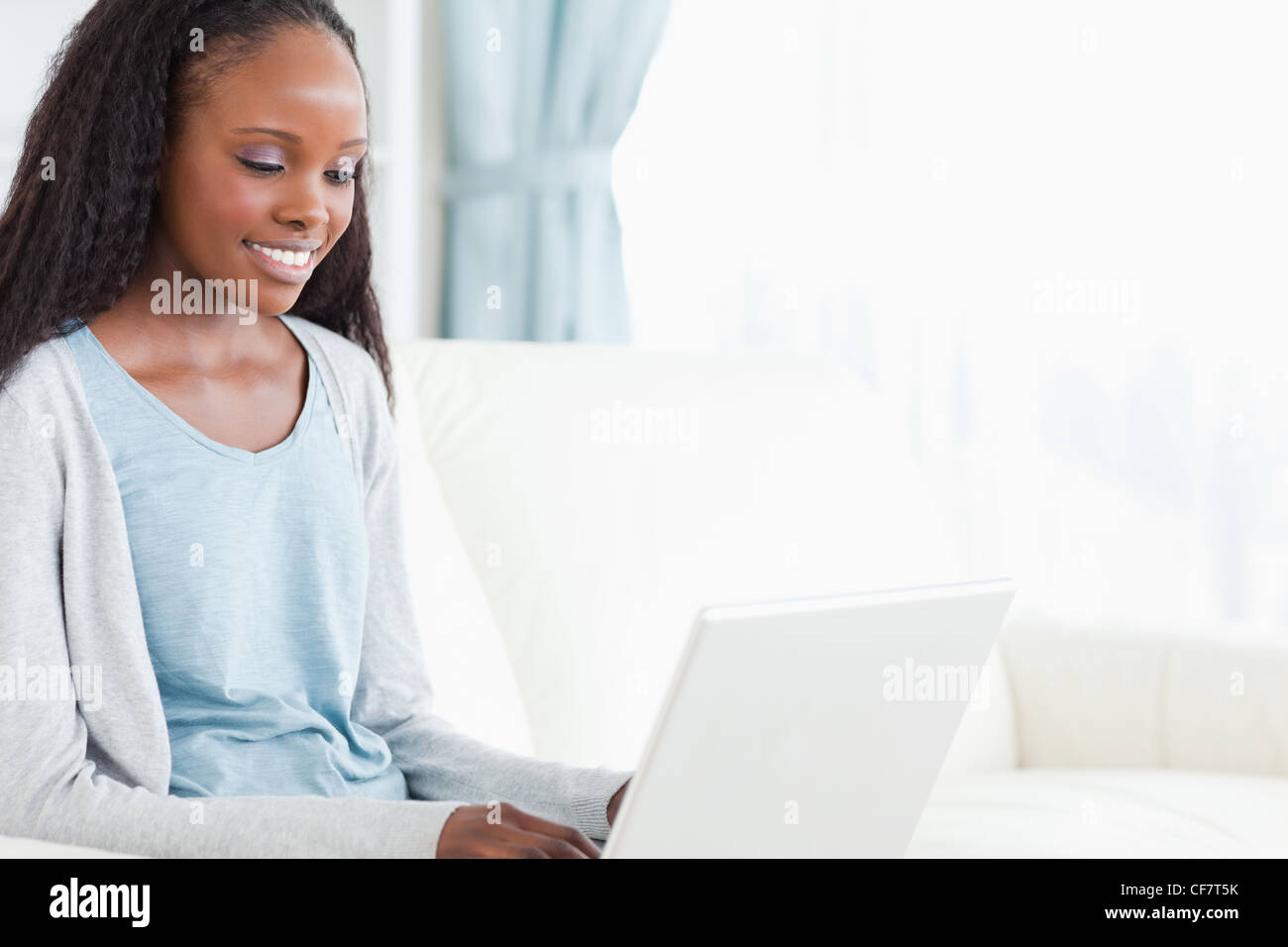 Young woman on sofa with laptop Stock Photo - Alamy