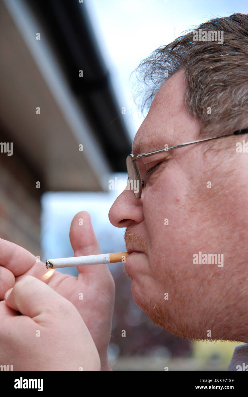 Man lighting up a cigarette model release Stock Photo