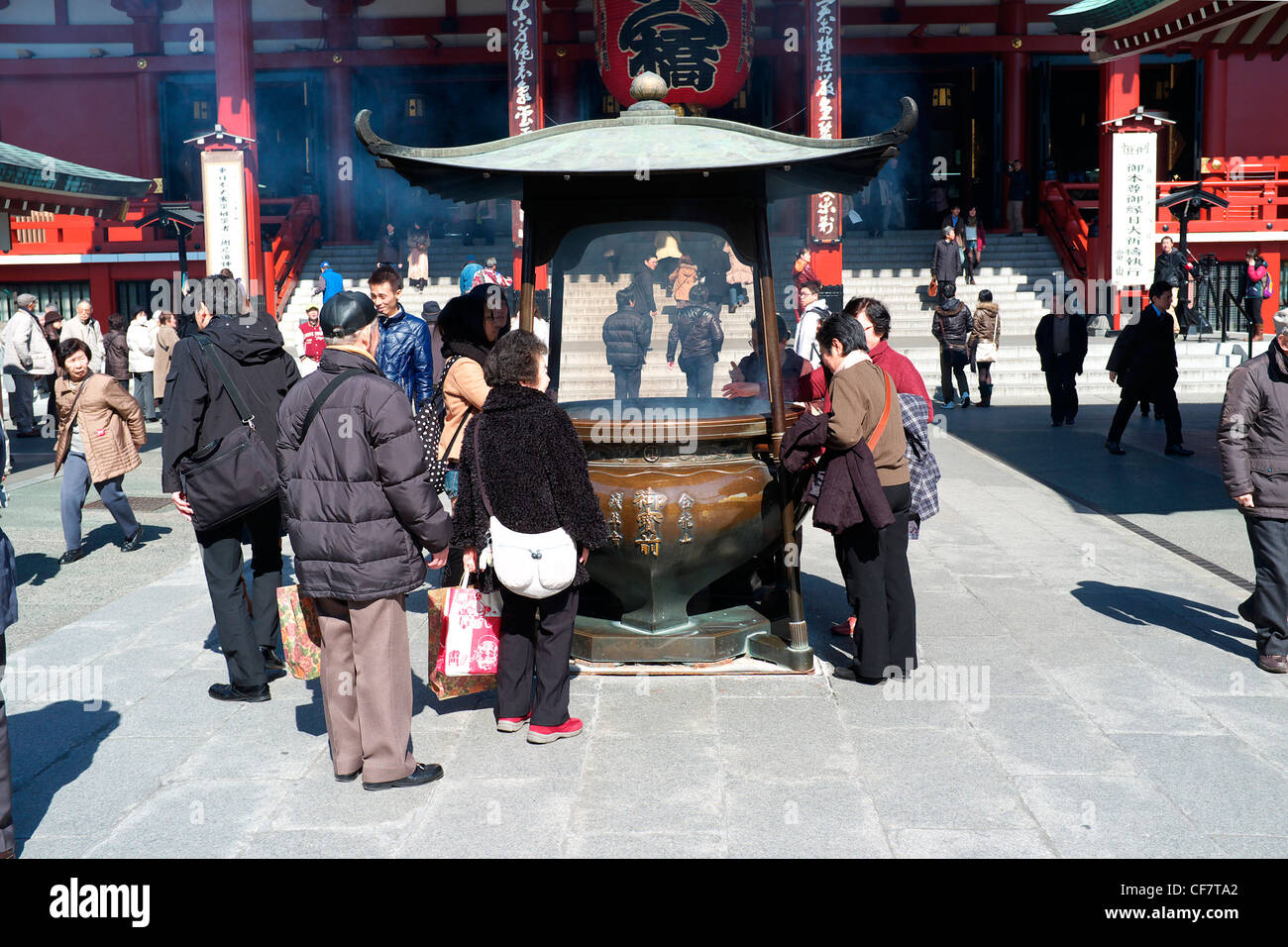 Tourist and devotees around an incense burner at the Senso-Ji Temple in ...