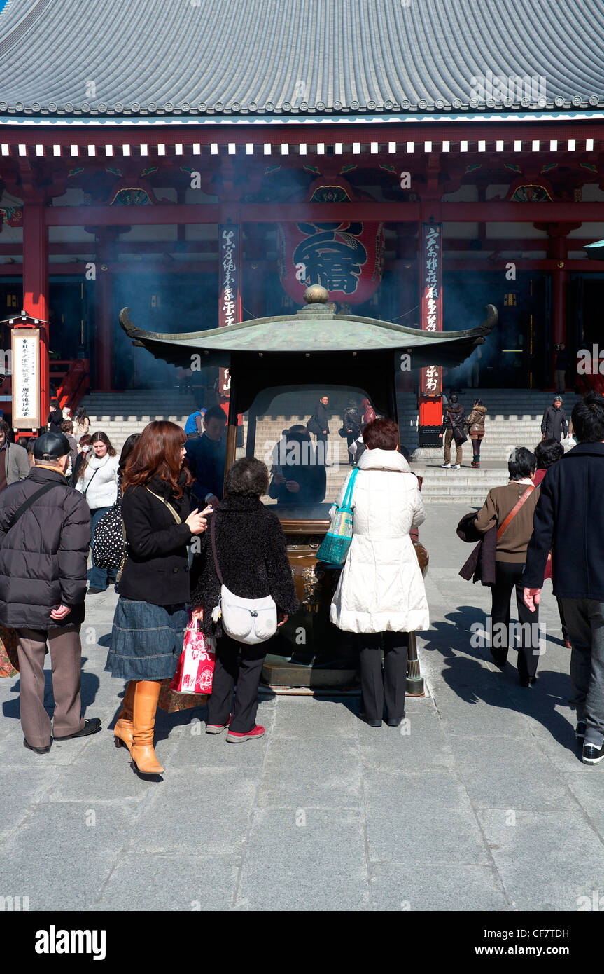 Tourist and devotees around an incense burner at the Senso-Ji Temple in ...