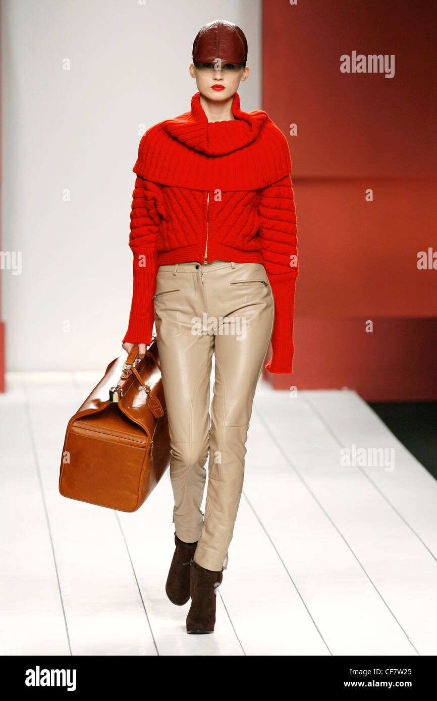 Etienne Aigner Milan Ready to Wear Autumn Winter Brown leather cap, red  zipper jacket, beige leather narrow legged trousers Stock Photo - Alamy