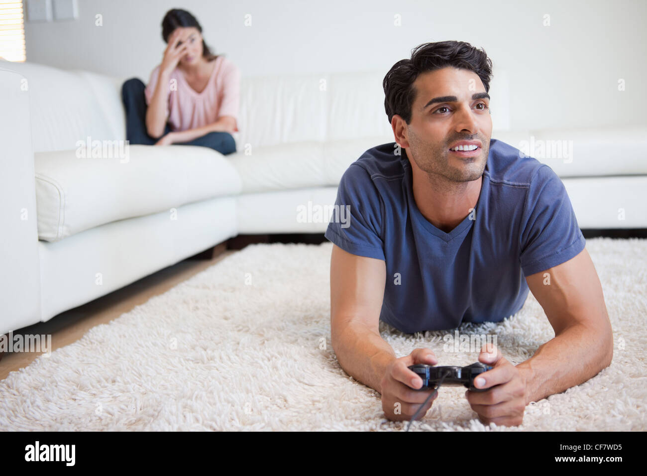 Man beating woman at video games with controller on console over blue  background. Boyfriend celebrating win and girlfriend feeling disappointed  about losing online gameplay in studio Stock Photo - Alamy