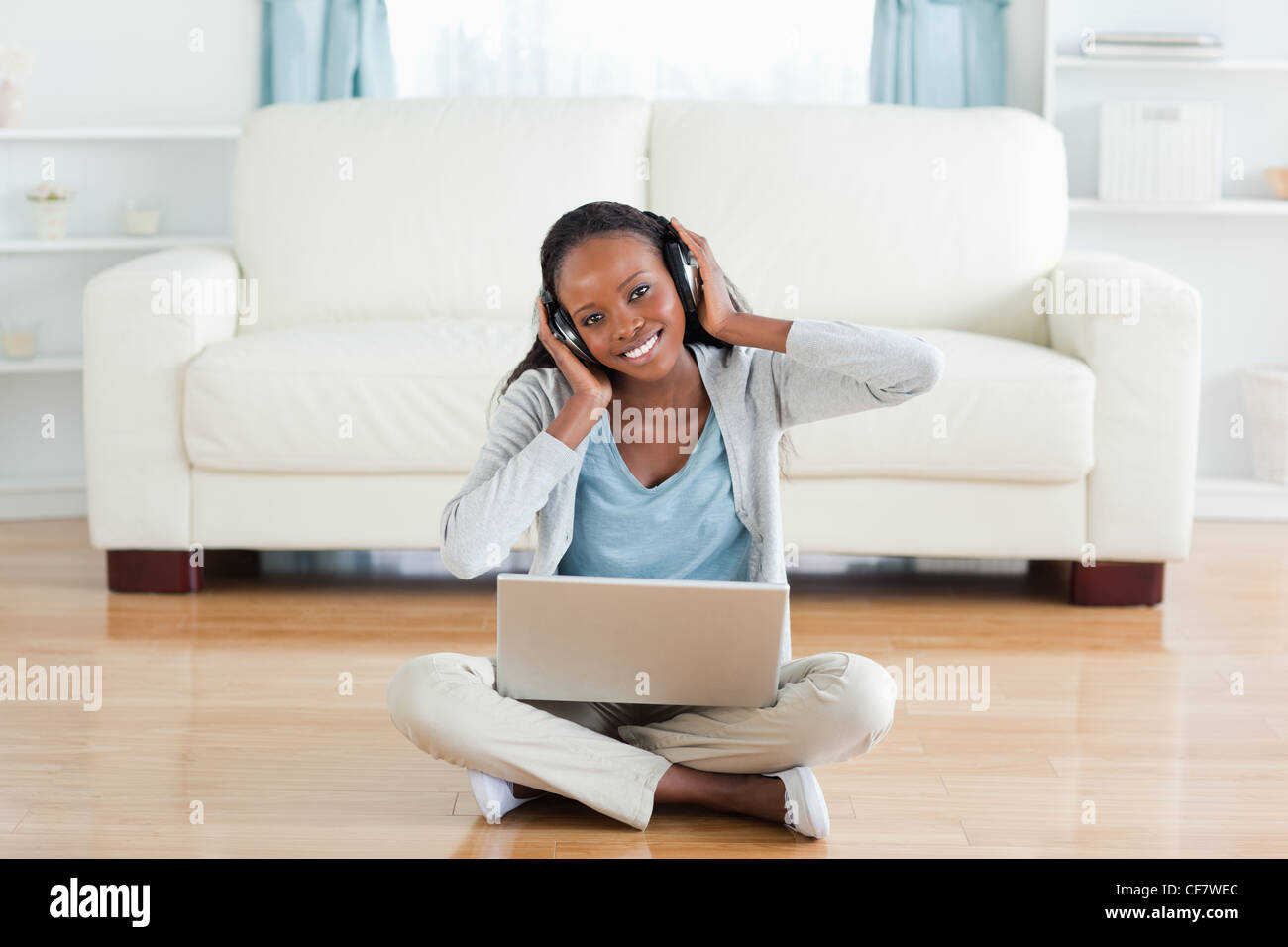 Woman sitting on the floor enjoying music Stock Photo - Alamy