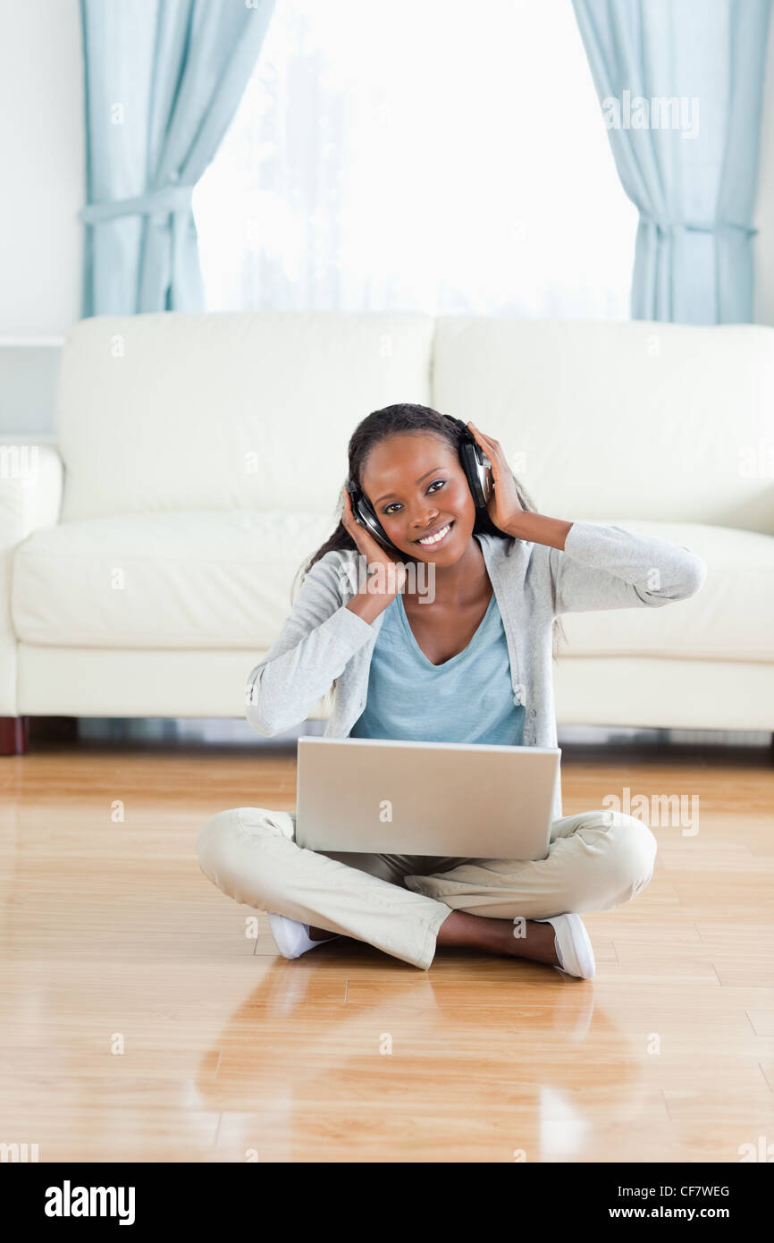Woman sitting on the floor listening to music Stock Photo - Alamy