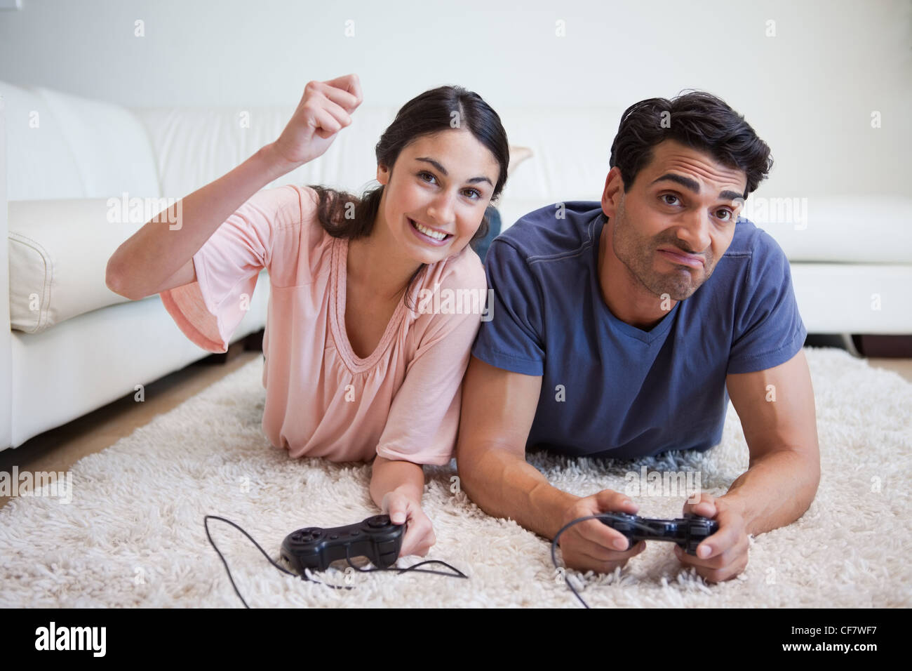 Woman beating her boyfriend while playing video games Stock Photo