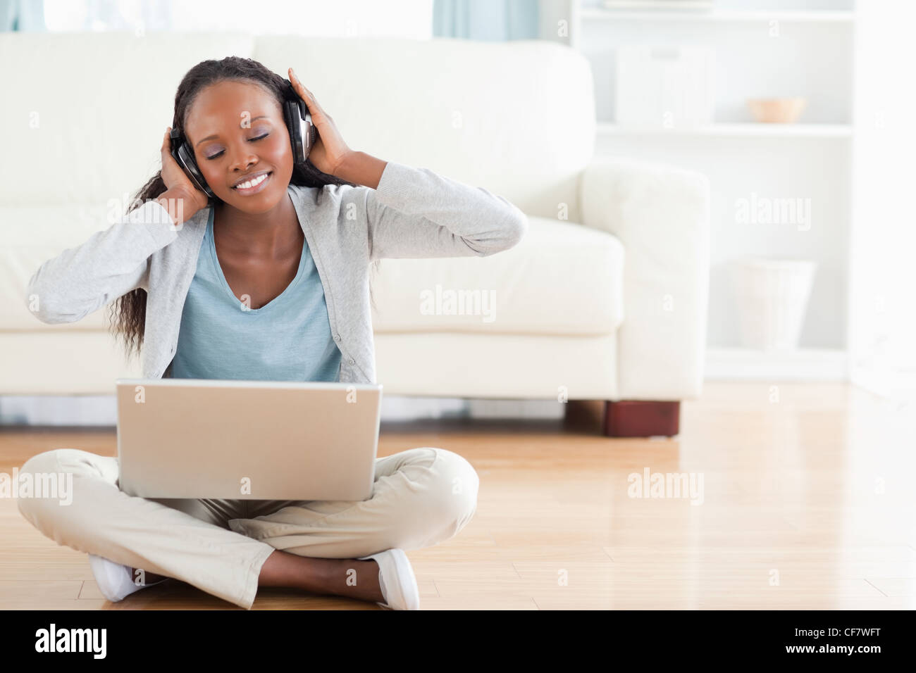 Woman on the floor listening to music Stock Photo - Alamy