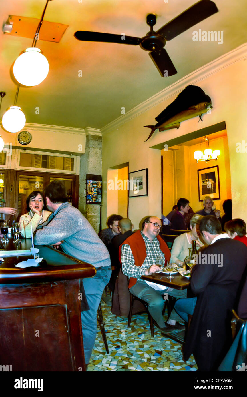 PARIS, France - People Sharing Meals and Drinks inside a local French Bistro, Wine Bar in the Belleville District- "Le Baratin" lights bistrot Stock Photo