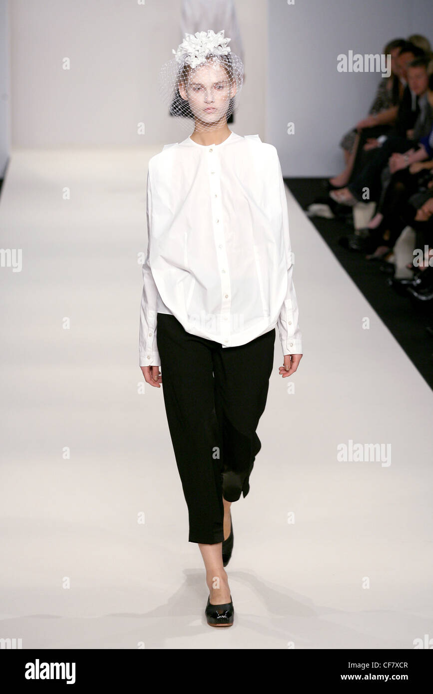 John Rocha London Ready to Wear Spring Summer Monochrome: white powder, white blouse and black cropped trousers, flat pumps and Stock Photo