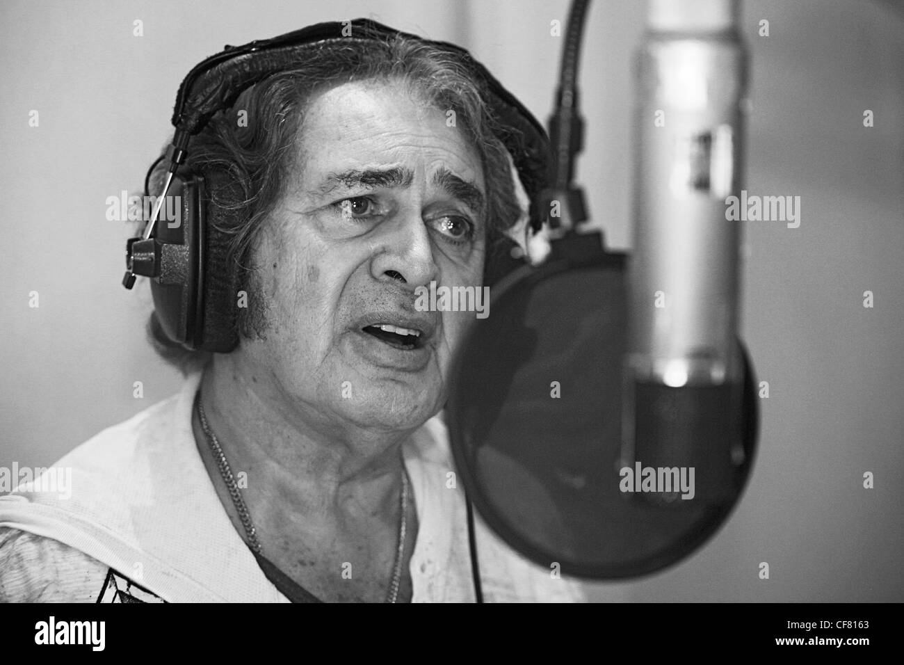 Engelbert Humperdinck UKs Eurovision entery singing in a recording studio with headphones on and singing into a microphone Stock Photo