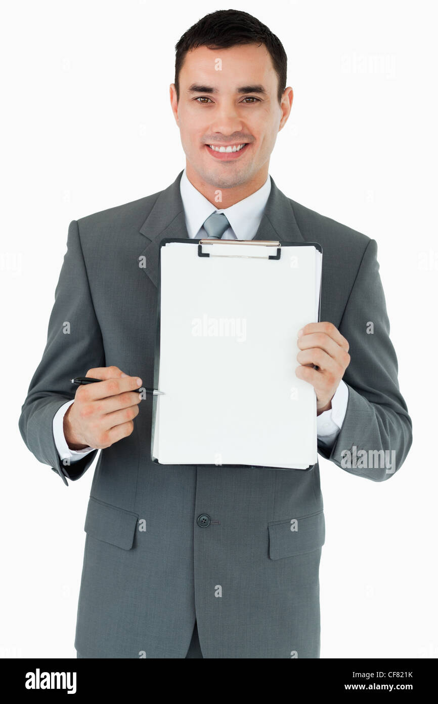 Smiling businessman pointing with pen at clipboard Stock Photo - Alamy