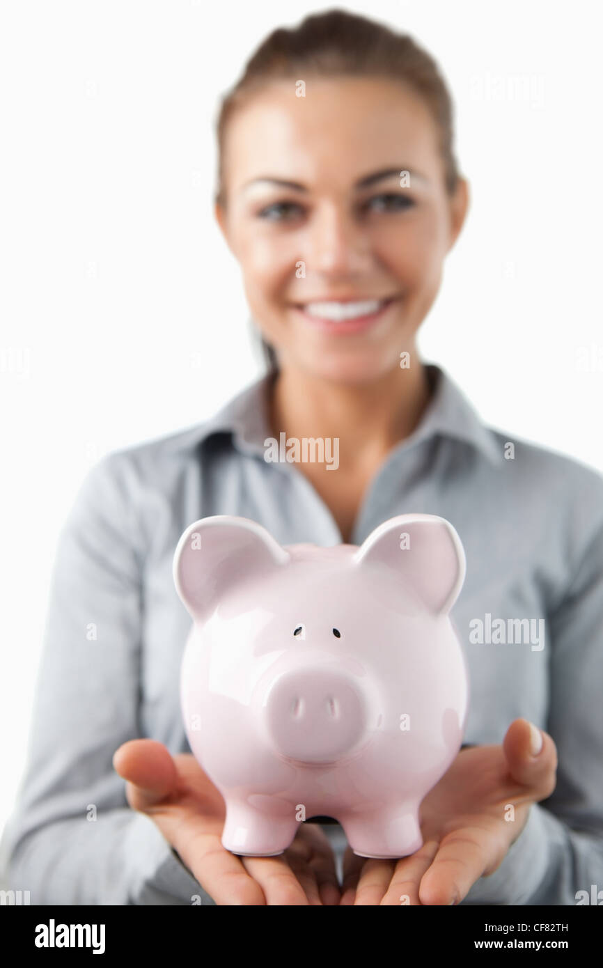 Close up of piggy bank being held by smiling female bank assistant