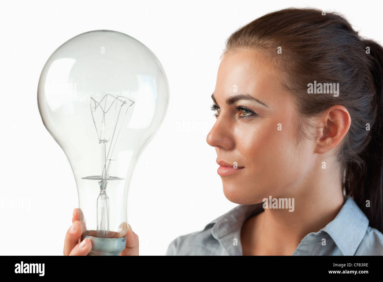 Businesswoman looking at huge light bulb in her hand Stock Photo