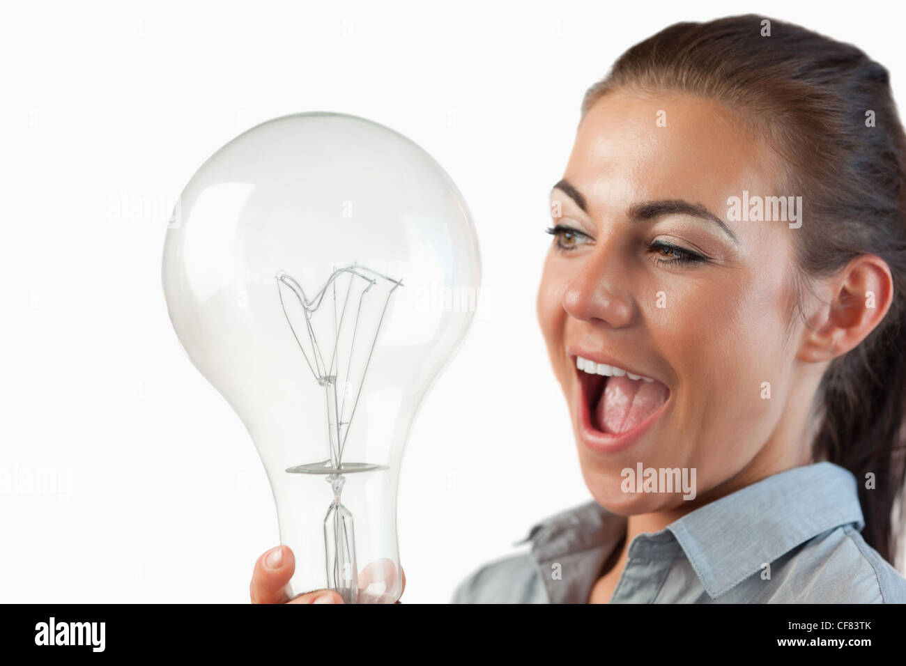 Close up of businesswoman being surprised by huge light bulb Stock Photo