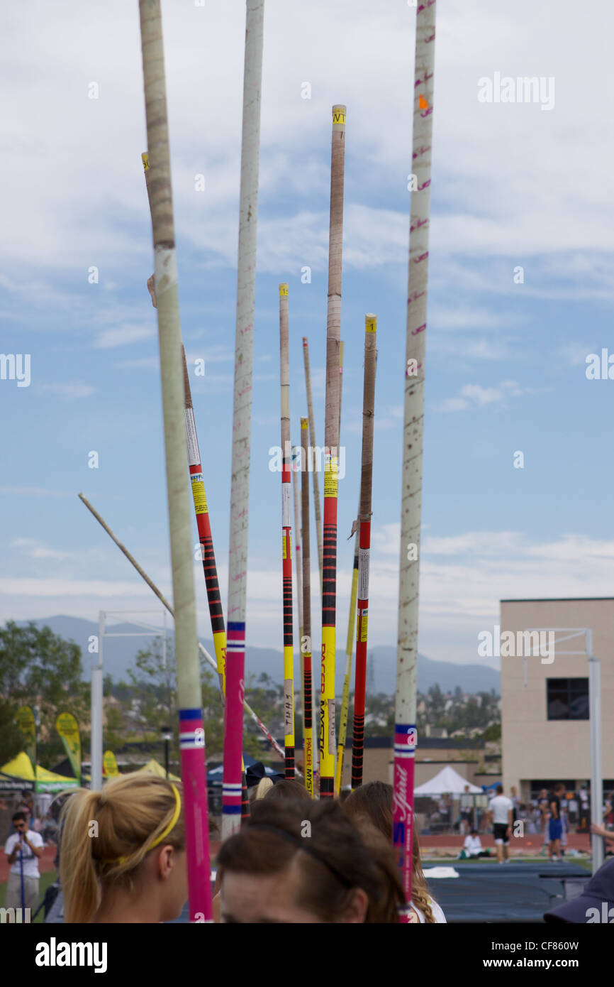 A line of pole vaulters waiting to warm up at a high school track meet