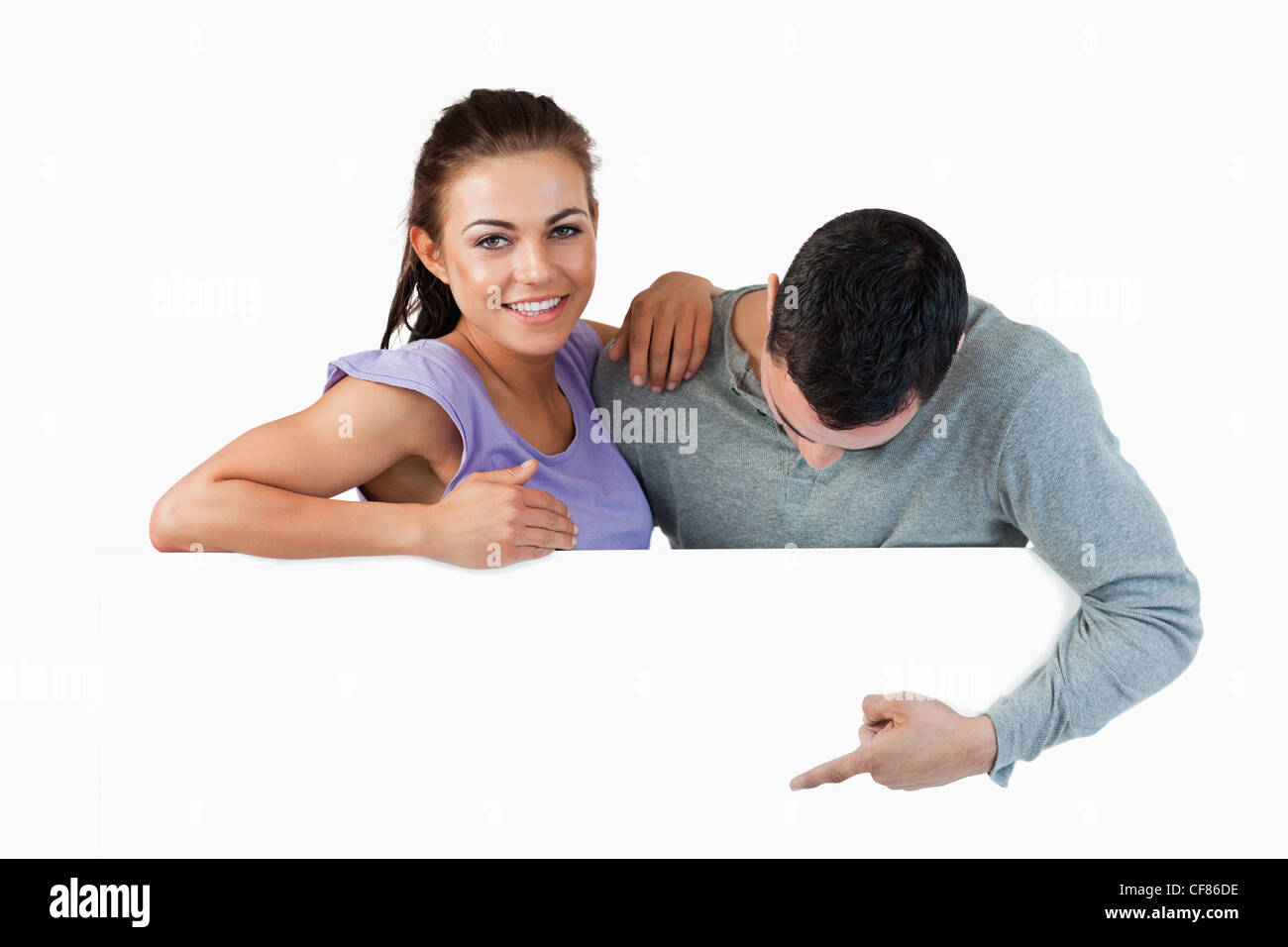 Smiling young female with her boyfriend behind a wall Stock Photo - Alamy