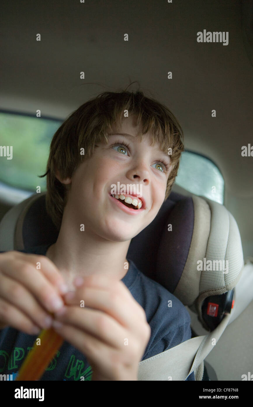 Eight year old boy looking our of car window with expression of wonder and amazement. Stock Photo