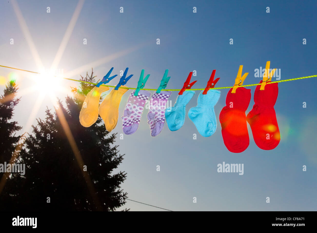 baby socks on clothesline to dry. blue sky Stock Photo Alamy