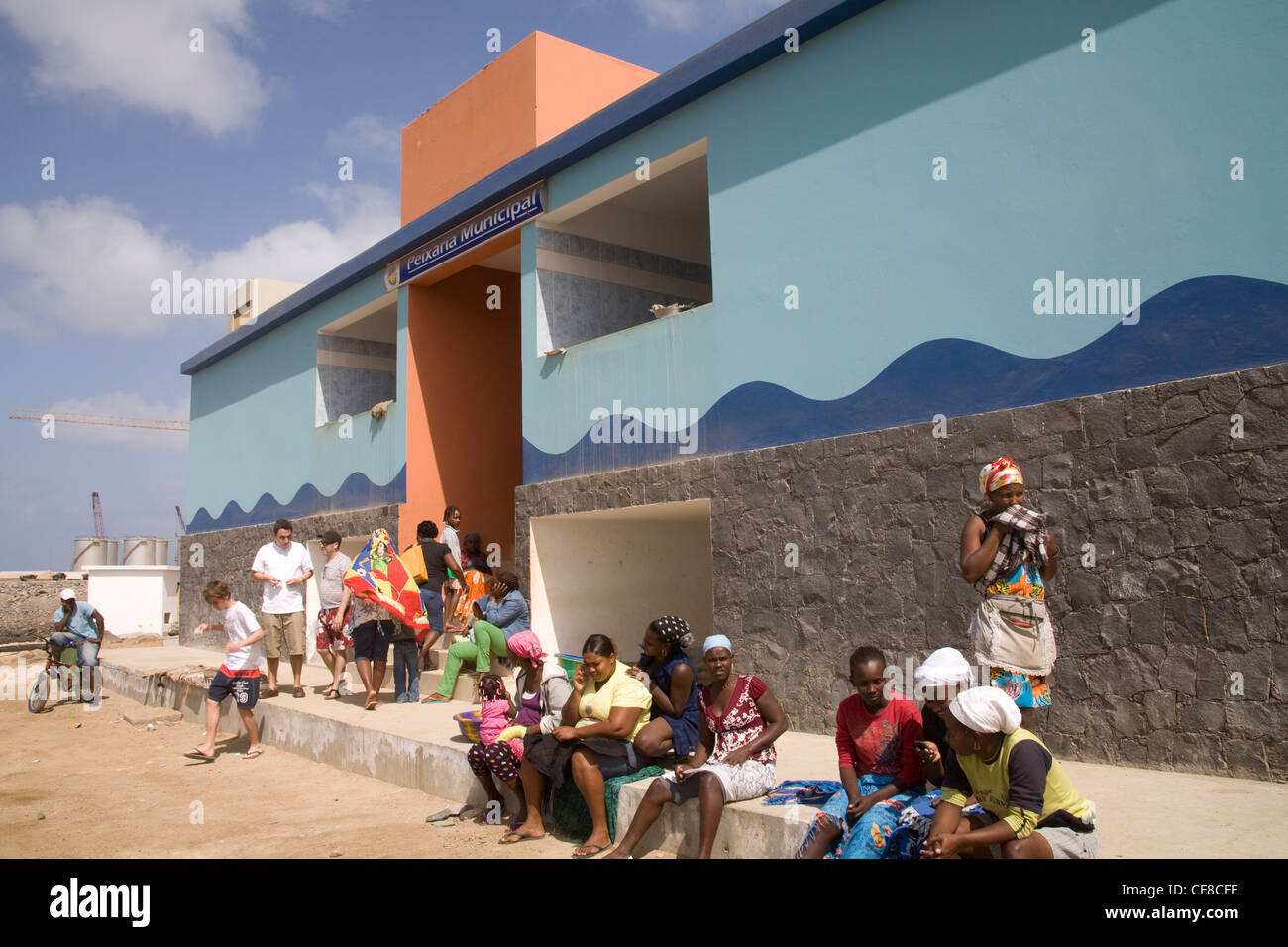Sal Rei Boa Vista Cape Verde Local women sitting outside Municipal fish market two using mobile phones Stock Photo