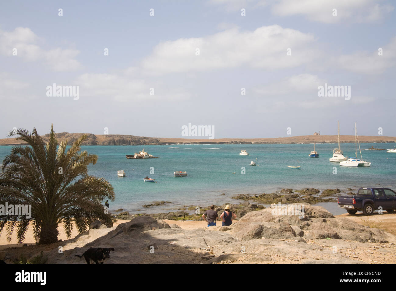 Sal Rei Boa Vista Cape Verde View across fishing boats moored in harbour to offshore island with its church Stock Photo