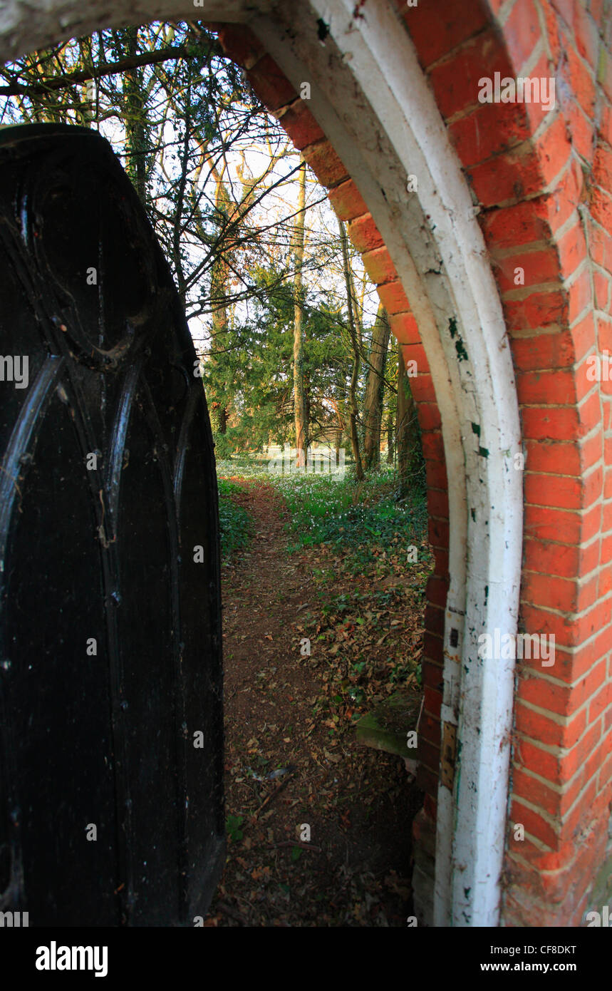 An arched doorway into tthe snowdrop walk at Little Walsingham in Norfolk. Stock Photo