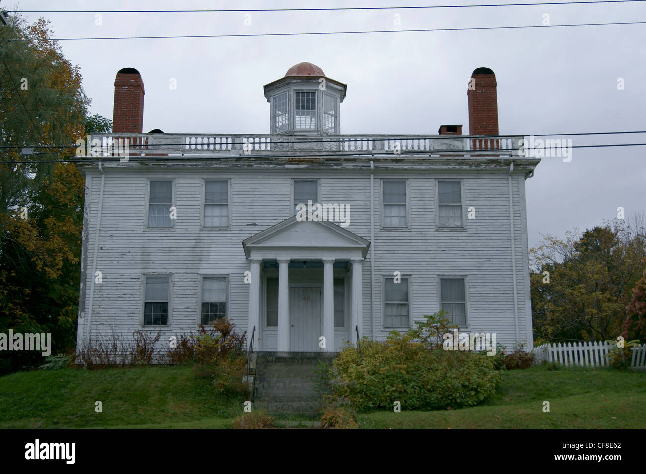 Square building with widow's walk and four chimneys in need of renovaton in Belfast Historic District, Belfast, Maine. Stock Photo