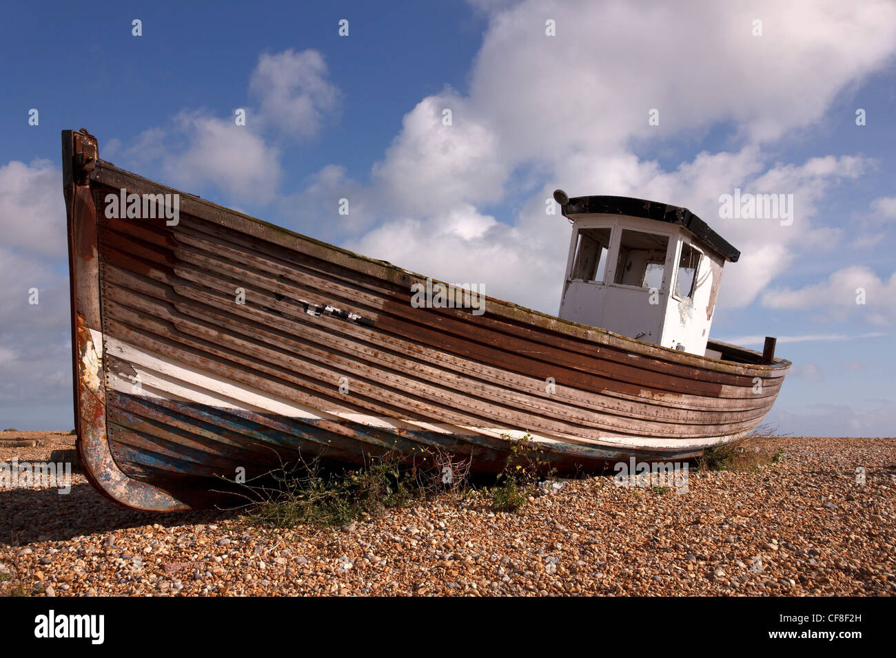 Old, clinker built, wooden fishing boat on shingle beach ...