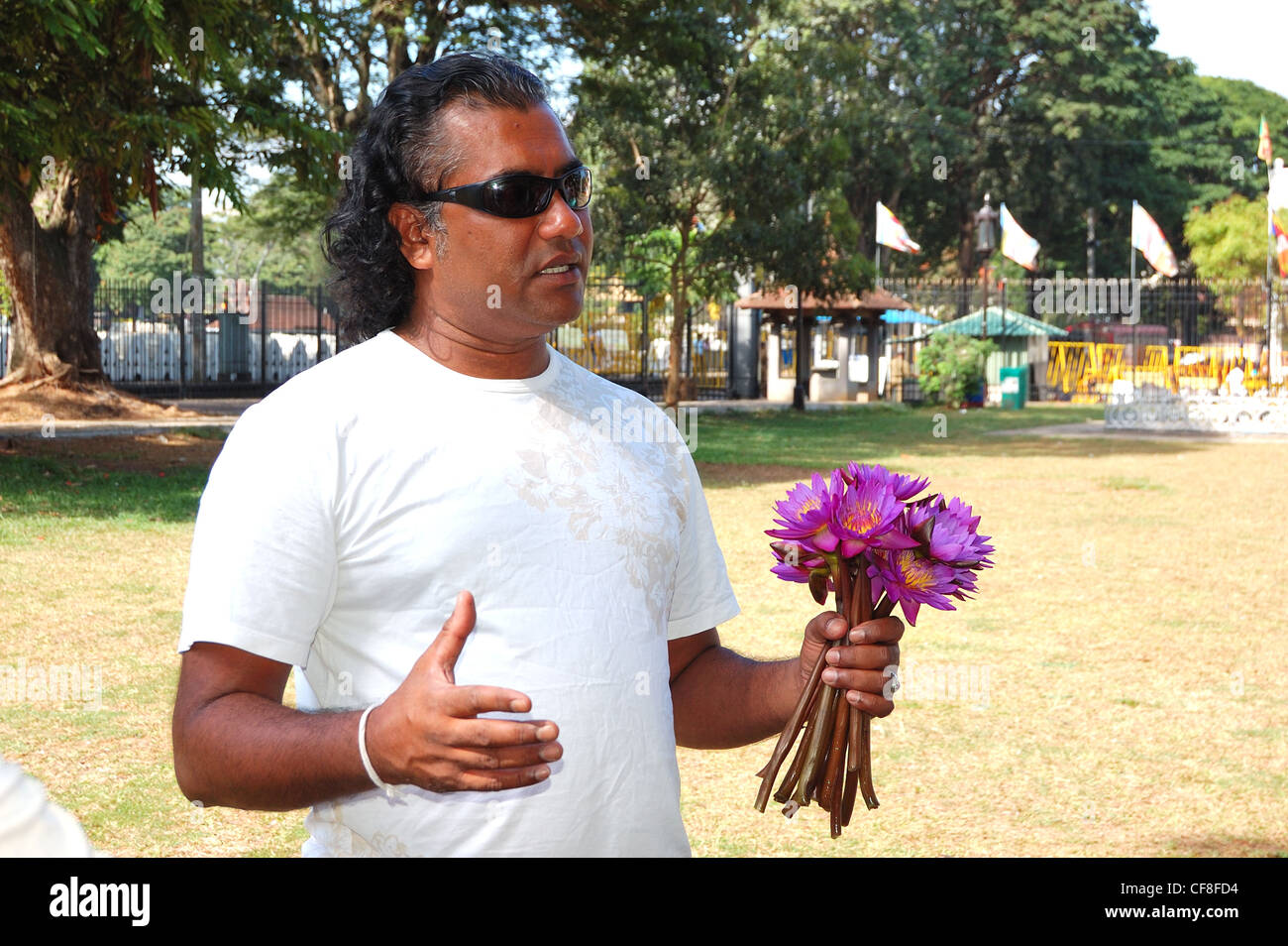 Local tourist guide with bouquet of lilies tells the Tooth Relic story